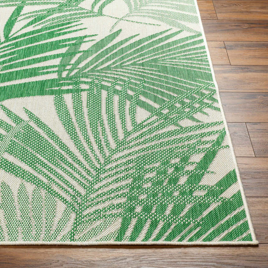 Close-up of the Jaala Area Rug showing a green and beige tropical palm leaf pattern on a machine-woven, rectangular rug. Front