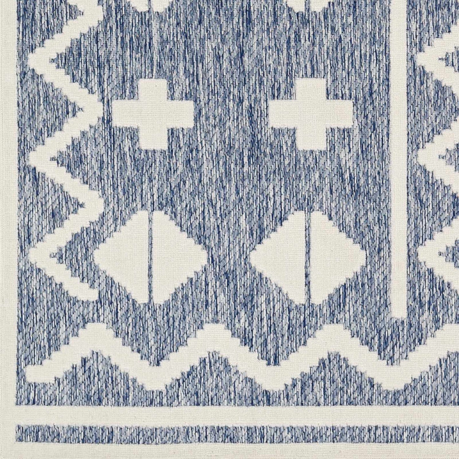 Close-up of Elio Blue Outdoor Rug, featuring a geometric pattern in denim blue and white. Contemporary style. Swatch