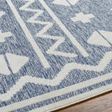 Close-up of Elio Blue Outdoor Rug showing geometric white pattern on denim blue textured weave. Texture