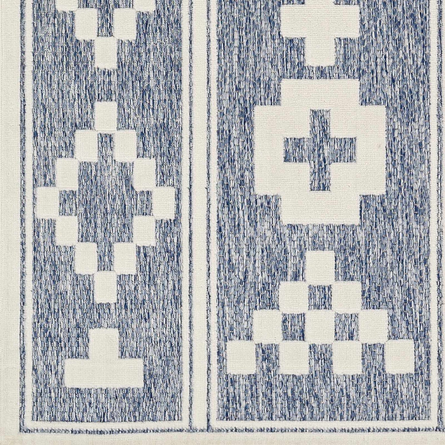Close-up of the Hiro Blue Outdoor Rug showing its denim blue and white geometric pattern and woven texture. Swatch