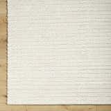 Close up of the hand woven Lenci Rose Cream Area Rug showing beige, ivory, and cream colors and wool texture. Corner