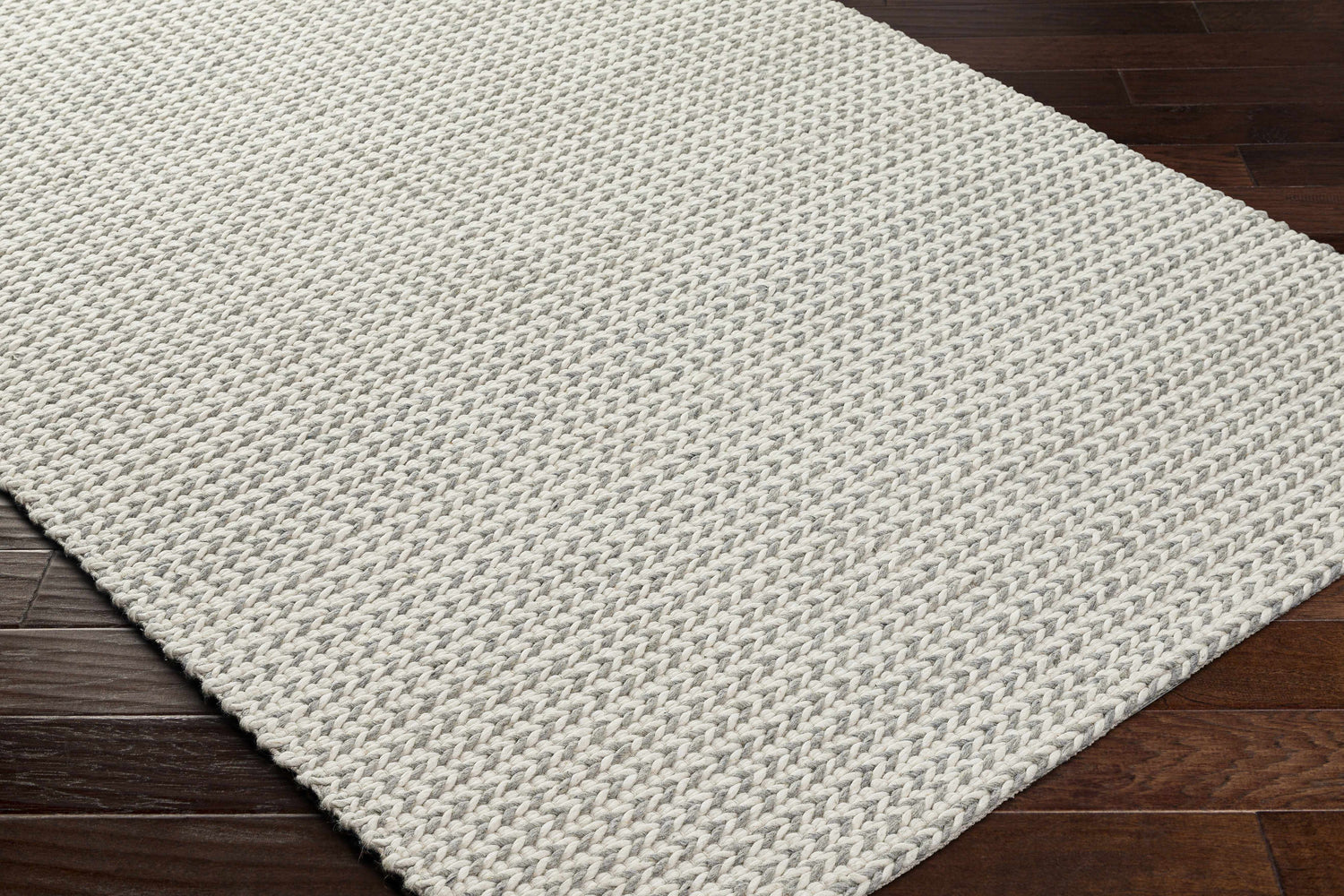 Close-up of the hand woven Lenci Bone Area Rug showing beige and bone colors and textured wool and cotton blend. Corner