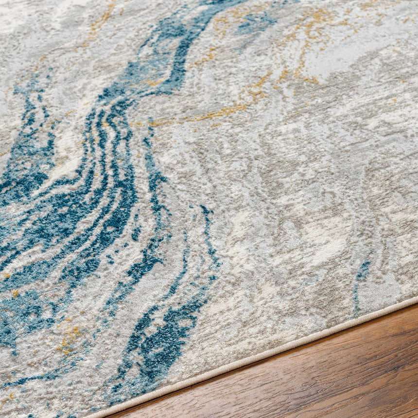 Close-up of the Tess Silver Blue Marble Area Rug showing its silver, blue, and gold marble-like pattern and soft texture. Texture