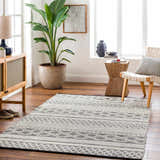 Living room scene with a geometric Hala Area Rug in dark gray, nickel, off-white, smoke, and taupe colors. Scandinavian style. Roomscene-Rectangle