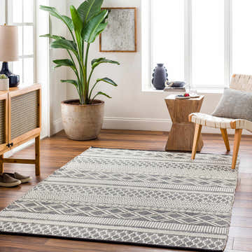 Living room scene with a geometric Hala Area Rug in dark gray, nickel, off-white, smoke, and taupe colors. Scandinavian style. Roomscene-Rectangle