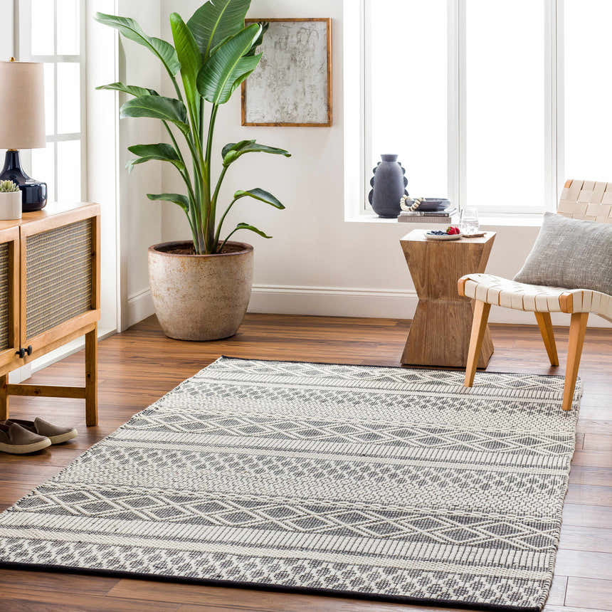 Living room scene with a geometric Hala Area Rug in dark gray, nickel, off-white, smoke, and taupe colors. Scandinavian style. Roomscene-Rectangle