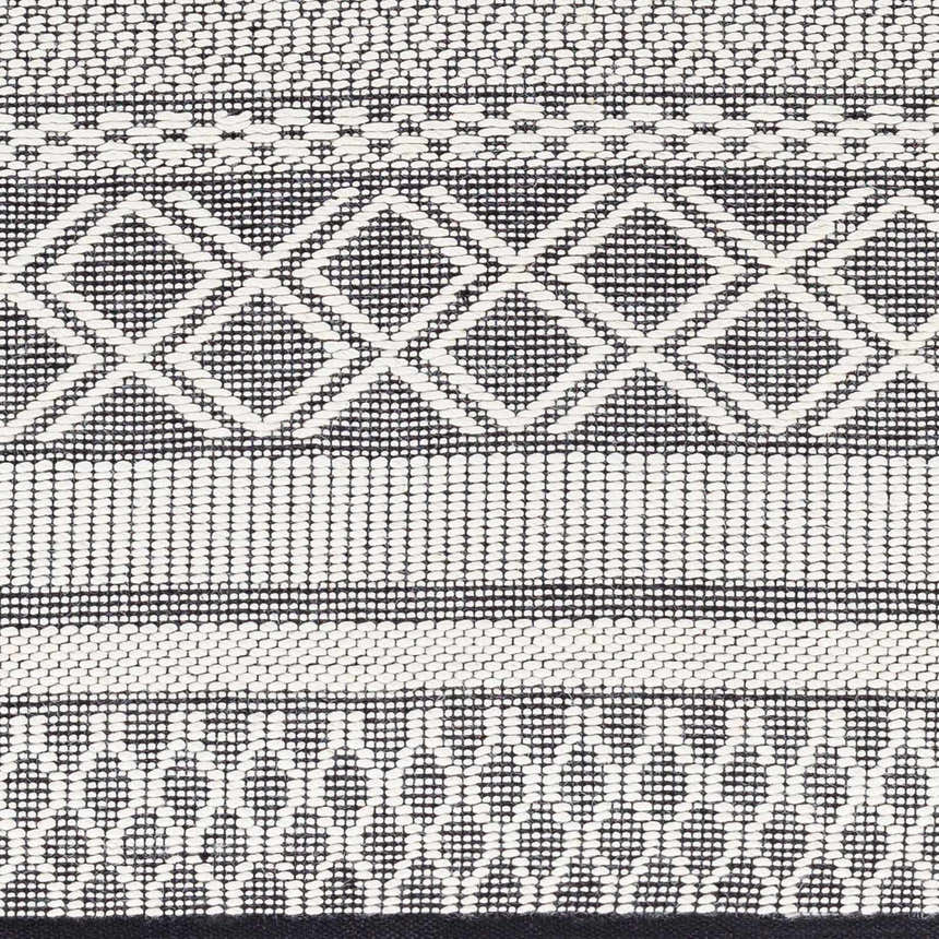 Close-up of the Hala Area Rug. Hand woven wool rug with geometric diamond pattern in dark gray, nickel, off white, smoke and taupe. Swatch
