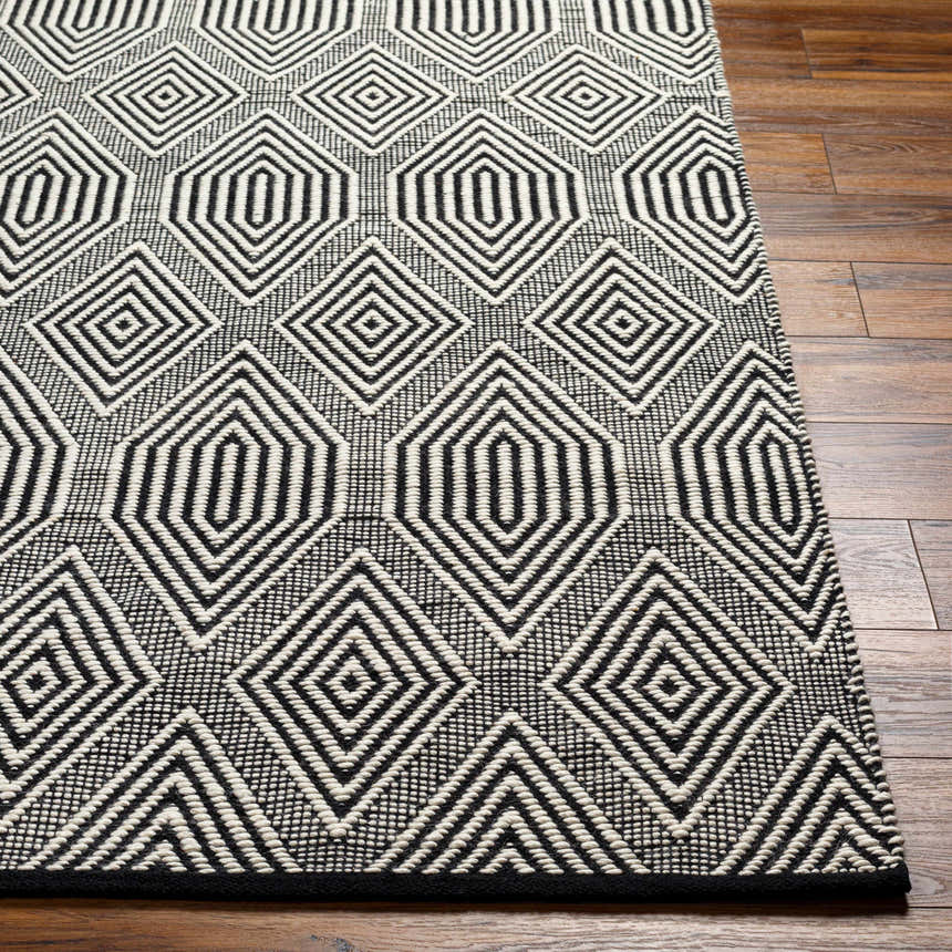 Close up of the Naya Area Rug showing a geometric diamond pattern in dark gray and silverton wool. Front