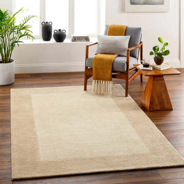 Living room scene with a beige Amadi Wool Area Rug, gray chair, wood side table, and dark wood floors. Roomscene-Rectangle
