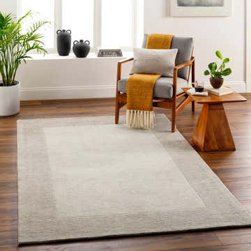 Living room scene with a beige Amadi Wool Area Rug, gray chair, and wooden accents. Roomscene-Rectangle