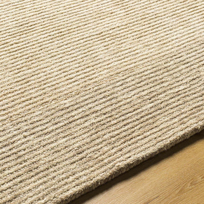 Close up of the hand-tufted Amadi Area Rug in pearl and tan, showing ribbed texture and wool material. Texture
