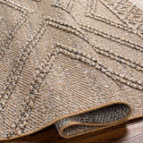 Close-up of the Beige Areli Area Rug showing its textured, geometric pattern in beige, black, and mustard tones. Fold