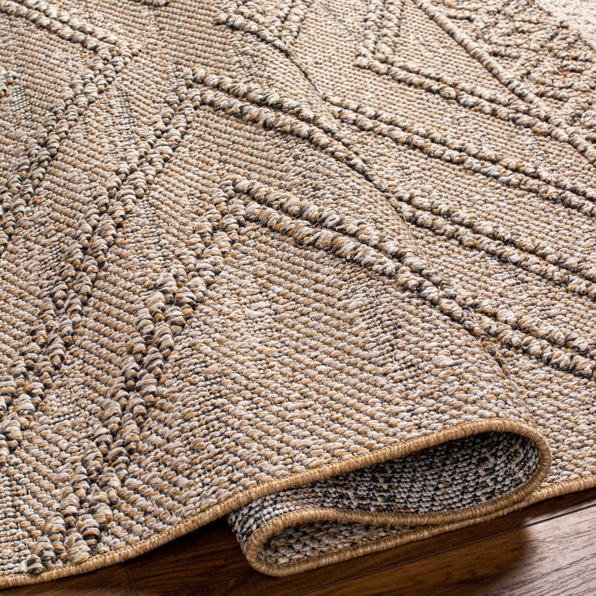 Close-up of the Beige Areli Area Rug showing its textured, geometric pattern in beige, black, and mustard tones. Fold
