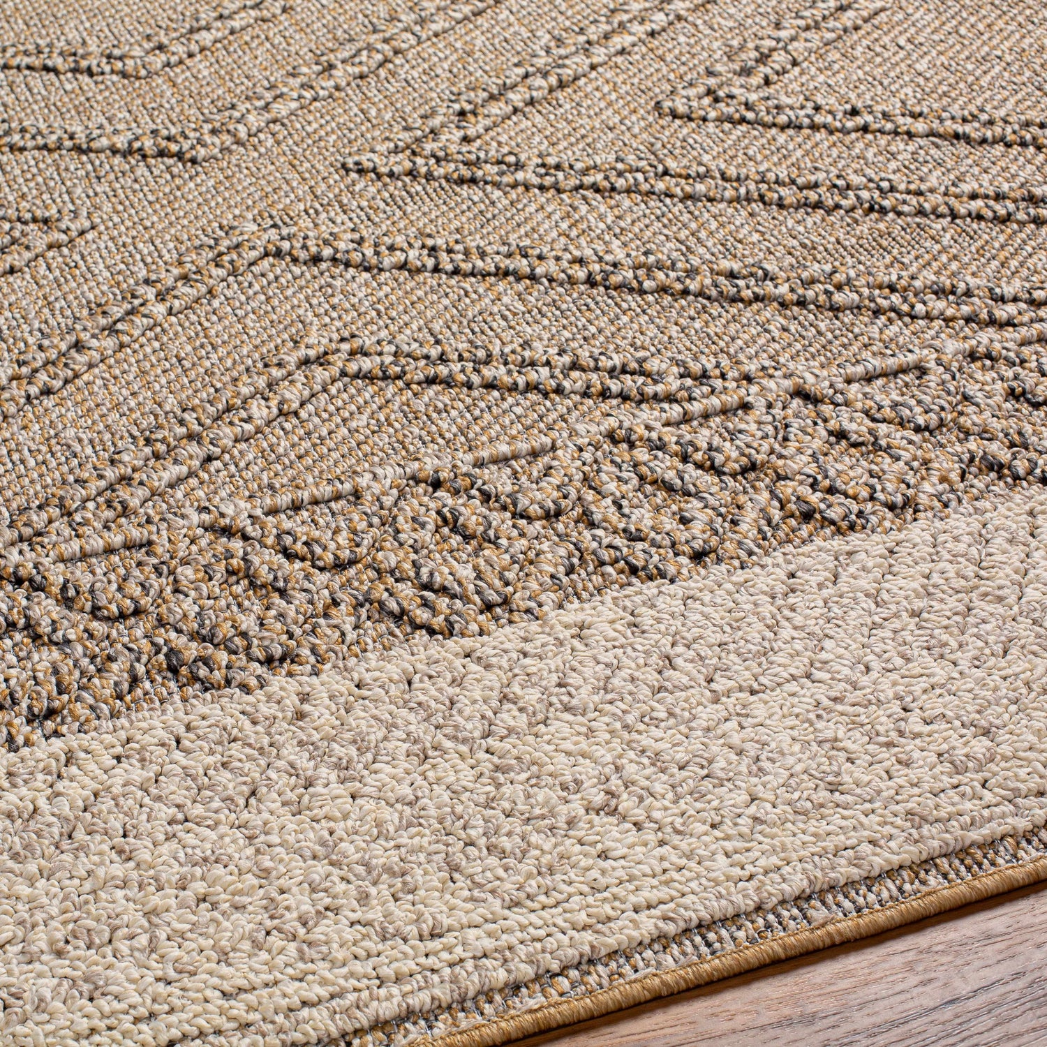 Close-up of the Beige Areli Area Rug showing its textured, geometric pattern in black, mustard, and taupe tones. Texture
