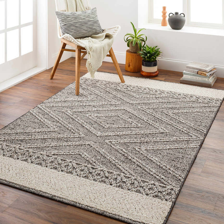 Living room scene with a beige and brown geometric Areli Outdoor Rug, chair, and wood floors. Roomscene-Rectangle