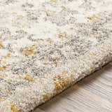 Close-up of the Stockwell Thick Luxe Rug. Ivory rug with a traditional pattern in gold, brown, and brick red tones. Texture