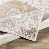 Close-up of the beige, black, and off-white Southwark Area Rug. Features a traditional, vintage-inspired geometric pattern. Fold