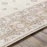 Close-up of the Southwark Area Rug showing its beige, mustard, and charcoal traditional pattern and machine woven texture. Texture