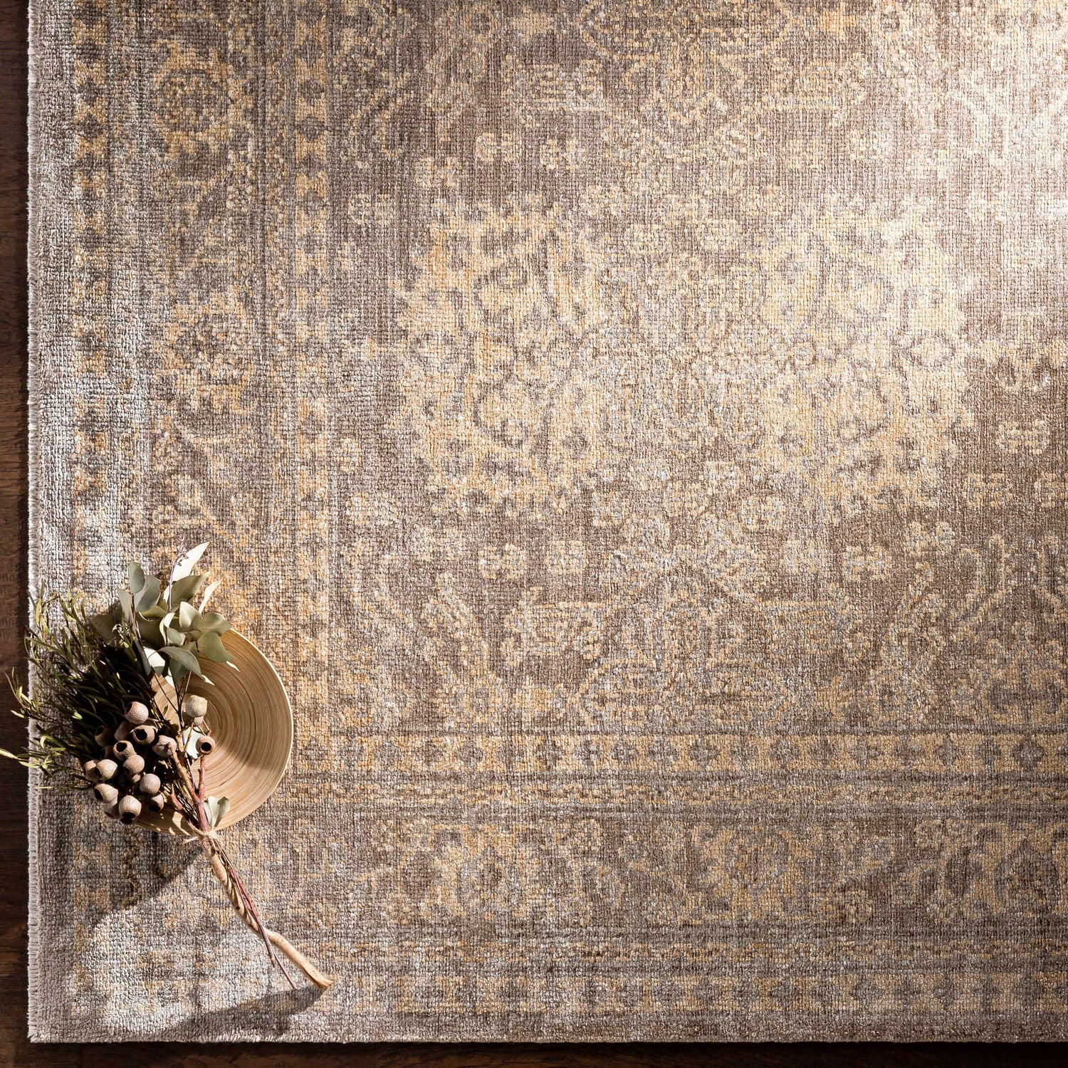 Close-up of the hand-knotted Stirum Area Rug. Light gray, taupe, and wheat hues create a traditional oriental pattern. Styleshot