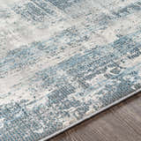 Close-up of the Stokenchurch Area Carpet. Contemporary style with blue, gray, and white abstract pattern. Machine woven texture. Texture