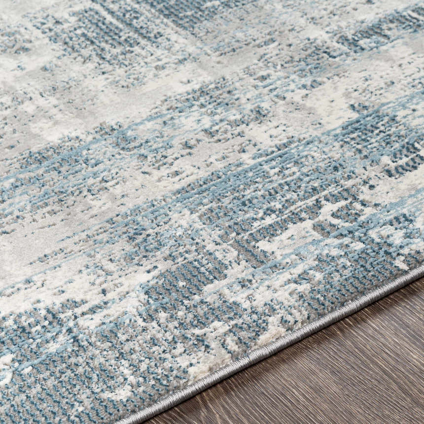 Close-up of the Stokenchurch Area Carpet. Contemporary style with blue, gray, and white abstract pattern. Machine woven texture. Texture