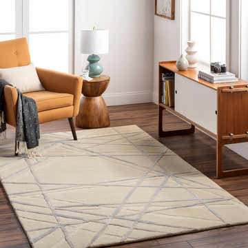 Living room with Amjad Area Rug, beige and gray geometric design. Mid-century modern style with orange chair and wood accents. Roomscene-Rectangle