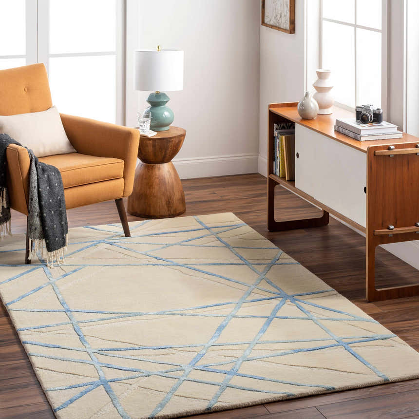 Living room scene with a beige Hiba Area Rug featuring a blue geometric pattern, paired with mid-century modern furniture. Roomscene-Rectangle