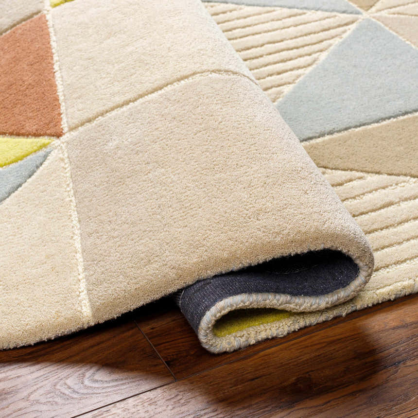 Close-up of the hand-tufted Mani Area Rug. Geometric design in camel, beige, gray, and oatmeal. Wool rug with textured pile. Fold