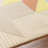 Close-up of the Mani Area Rug, a hand-tufted wool rug with a geometric pattern in camel, beige, and yellow tones. Texture