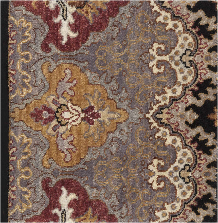 Close up of the hand-knotted Stoutsville Carpet featuring amber, brick red, and gray traditional patterns. Swatch