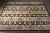 Close-up of the Stoutsville Carpet, a hand-knotted wool rug with amber, black, and brick red traditional patterns. Front