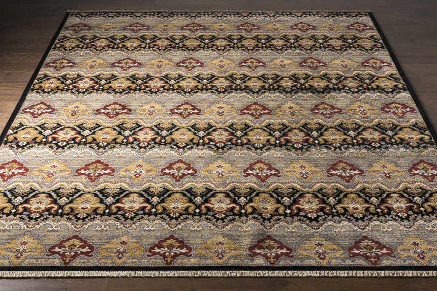 Close-up of the Stoutsville Carpet, a hand-knotted wool rug with amber, black, and brick red traditional patterns. Front