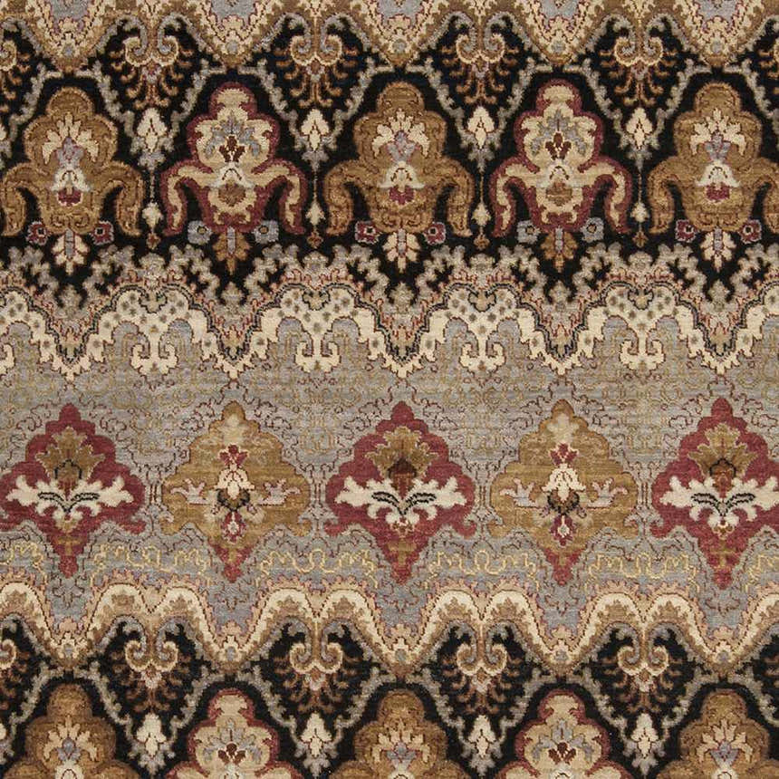 Close-up of the Stoutsville Carpet, a hand-knotted rug with amber, black, and brick red traditional patterns. Swatch