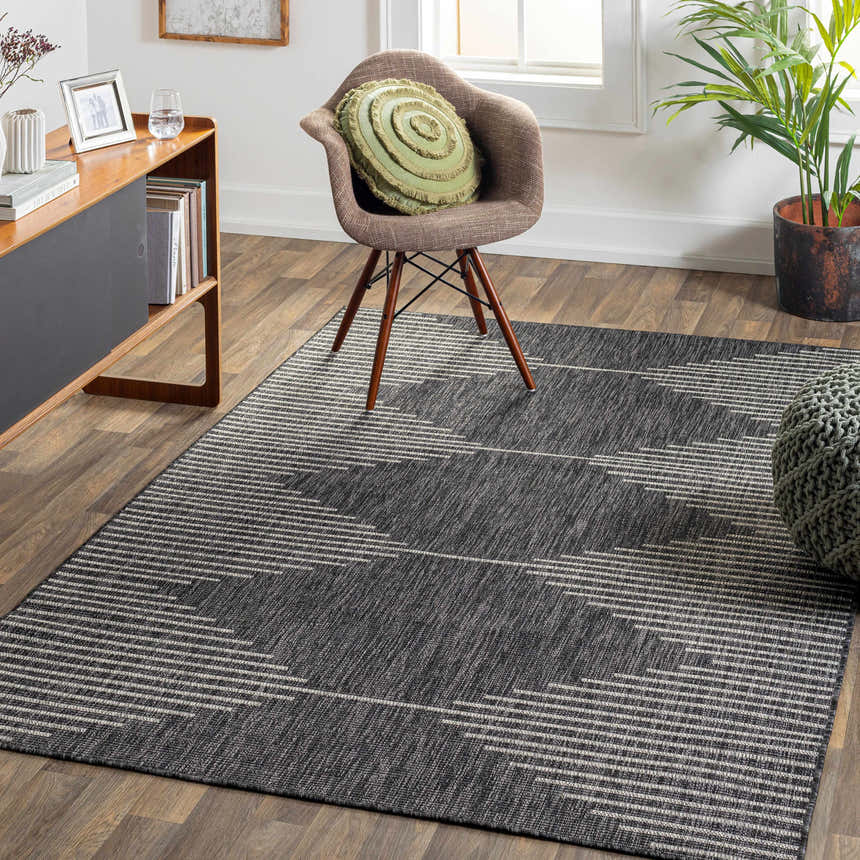 Living room scene with a black and cream Stephan Area Rug, wood floors, and mid-century modern furniture. Roomscene-Rectangle
