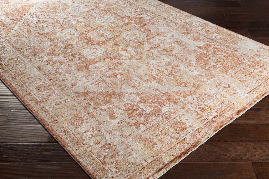 Close-up of Strathbogie Traditional Red Area Rug showing brick red, cream, and mustard colors on dark wood floor. Corner