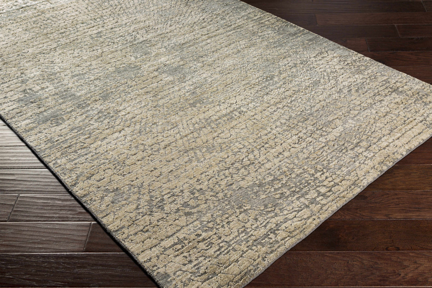 Close up of the beige and gray Streatley Area Rug with a contemporary abstract design on dark wood flooring. Corner