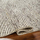 Close-up of the hand woven Caius Area Rug. Beachhouse and taupe stripes in a geometric, Scandinavian design. Fold