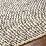 Close-up of the Caius Area Rug showing a geometric, striped pattern in beachhouse and multi brown wool. Texture