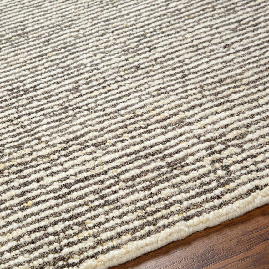 Close-up of the Caius Area Rug showing a geometric, striped pattern in beachhouse and multi brown wool. Texture
