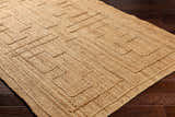 Close-up of the hand woven Tino Area Rug. Natural jute rug with a geometric, maze-like pattern in beige and tan. Corner