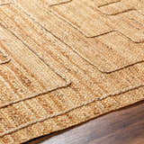 Close-up of the hand-woven Tino Area Rug. Jute rug in beige, tan, and brown with a geometric pattern. Texture