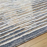Close-up of the Kylar Area Rug, featuring a contemporary striped pattern in gray, smoke, and gold tones. Texture