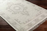 Close-up of the hand woven Afra Area Rug in cloud gray and dark gray with a traditional farmhouse pattern and fringe. Corner