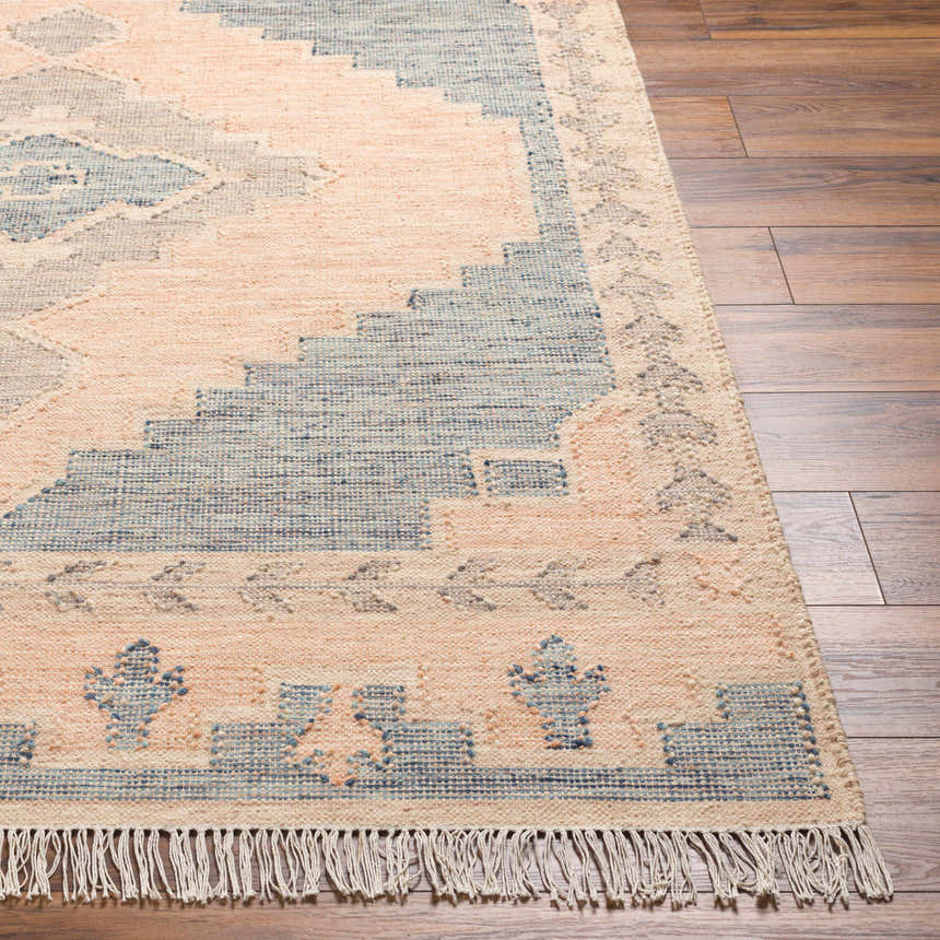 Close up of the hand woven Lana Area Rug with a traditional geometric pattern in light brown and blue. Front