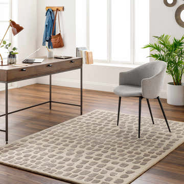Home office with Arjan Beige Area Rug, wood desk, gray chair, and natural light. Roomscene-Rectangle