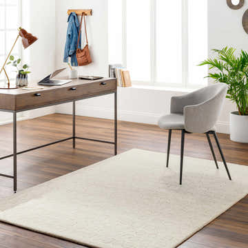 Home office with Arjan Cream Area Rug, wood desk, gray chair, and brown wood floors. Roomscene-Rectangle