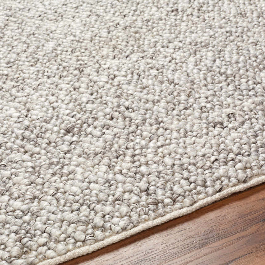 Close-up of the Chole Area Rug, a hand-woven rug with a gray and nutmeg textured design made of recycled PET yarn. Texture