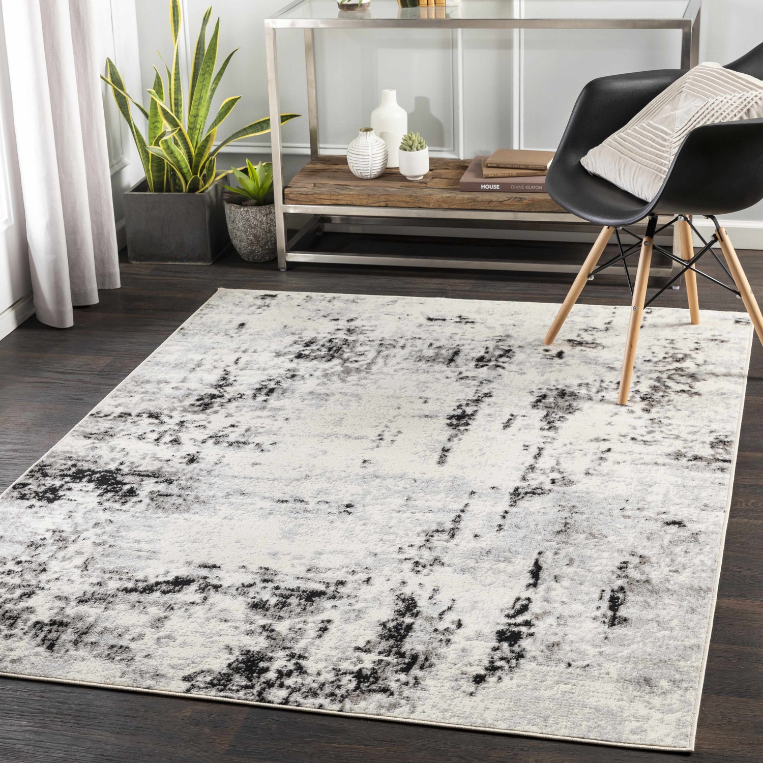 Contemporary living room scene with a black chair and the Swansboro Area Rug in black, charcoal, and gray. Roomscene-Rectangle