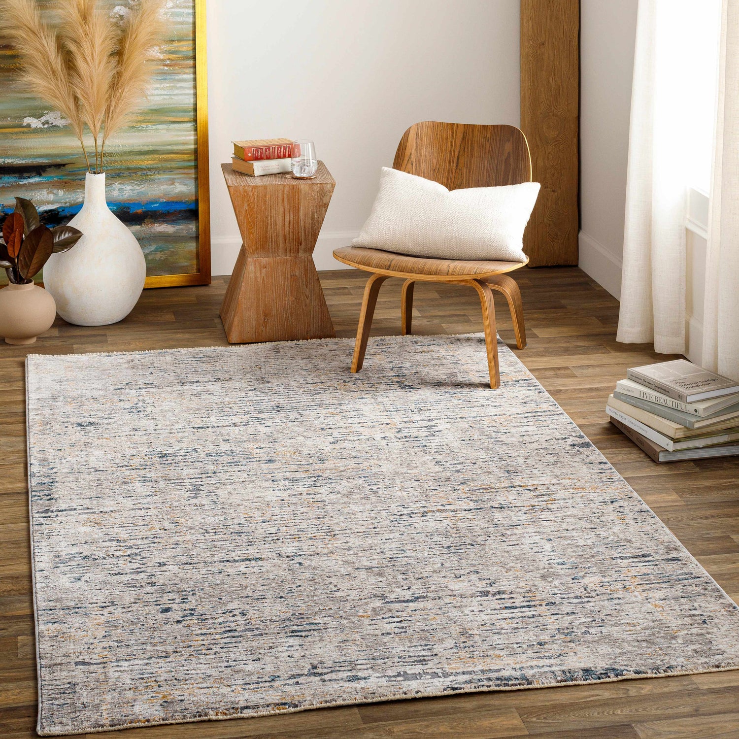 Living room scene with a beige and blue Sywell Luxe Fringe Rug, wood chair, and neutral decor. Roomscene-Rectangle