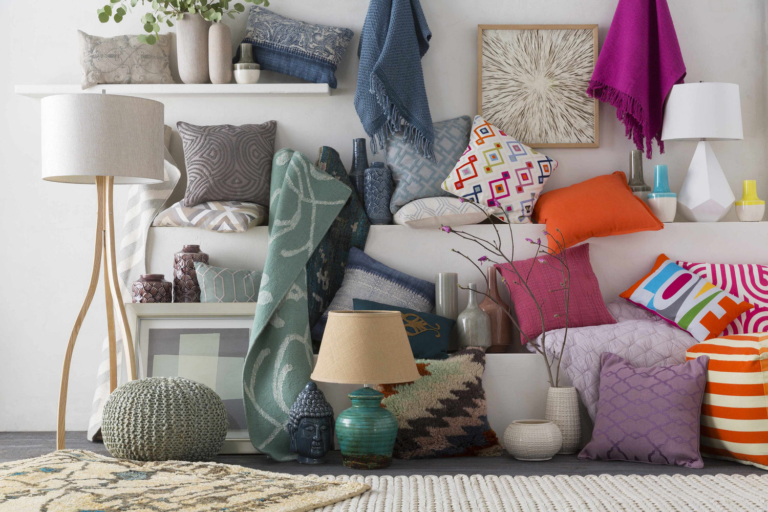 Eclectic room scene with the cream Christoval Area Rug, colorful pillows, lamps, vases, and art creating a cozy, layered look. Styleshot